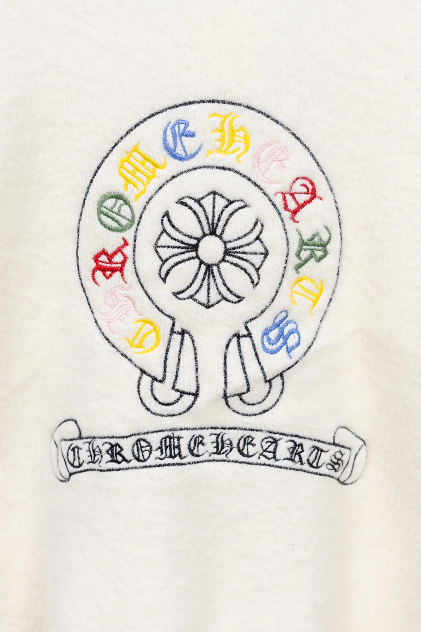 P300 Chrome Hearts CH Chrome Hearts 2026 new cross loose knitted V-neck cardigan Fabric: Made of plush textured knitted material, soft to the touch and with a lazy atmosphere; Decoration: Red, yellow, and black cross ornaments on the chest, paired with brand logo patches, which are iconic elements of street fashion brands (such as Chrome Hearts style), enhancing visual recognition; Version: Loose version + single-row metal button design, combining casual feeling and practicality. 2. Style and Adaptation Style: It combines dark street style and gentle knitted texture, which belongs to the tone of "sweet and cool mix"; Scenario: Can be worn with a T-shirt/suspender to create a daily street look, or can be layered with a shirt for light casual wear. Color: Black White Size: M L XL